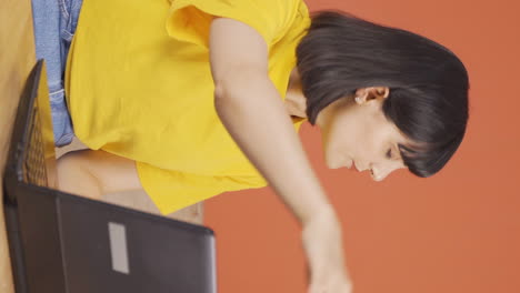 Vertical-video-of-Young-woman-closing-laptop-with-angry-expression.